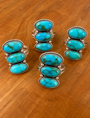 Turquoise Triple-Stone Rings on Wood.png
